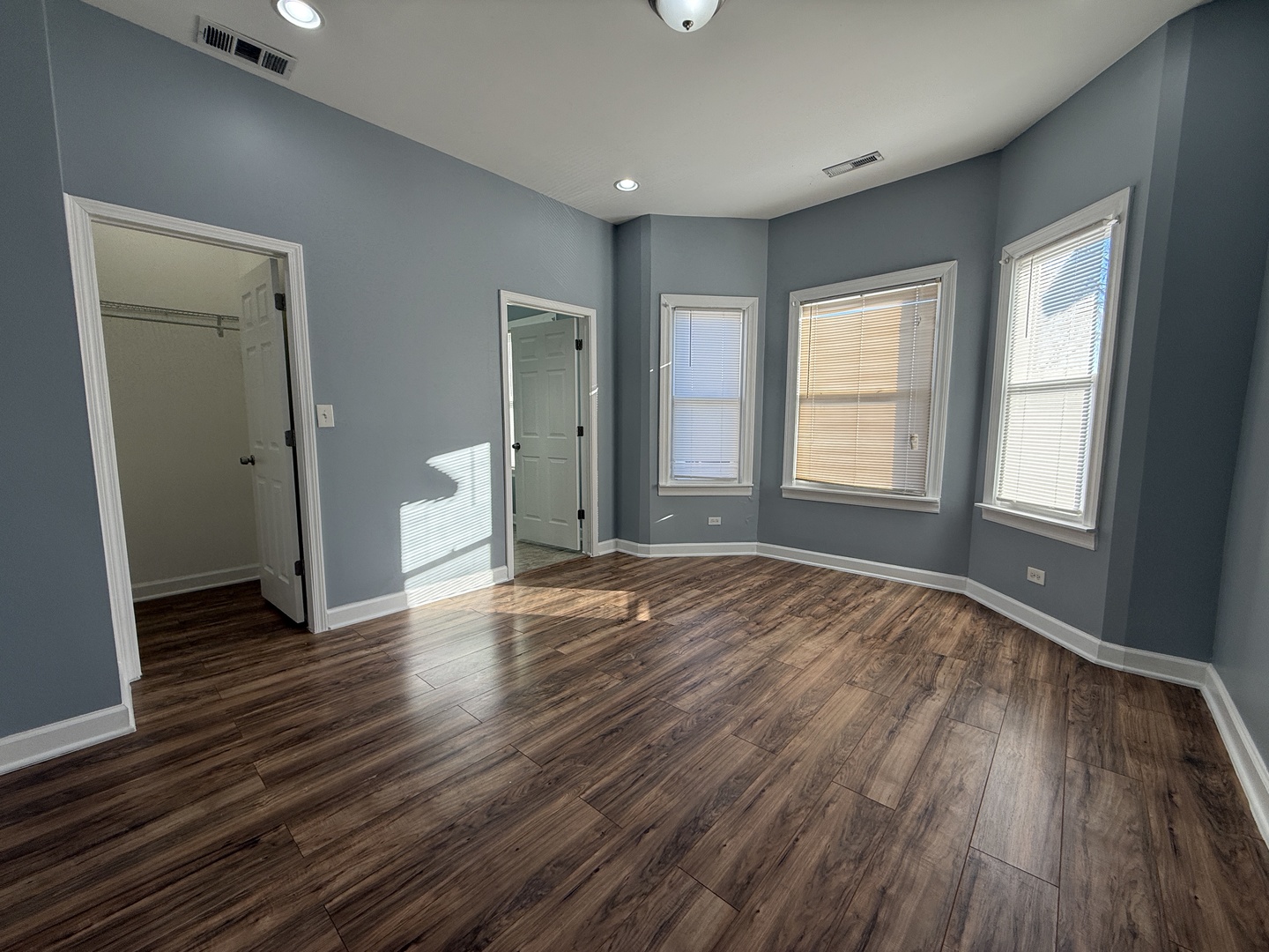 9738 South Ave L, Unit 2 Chicago, IL 60617 - Photo 7 of 11 an empty room with wooden floor and windows