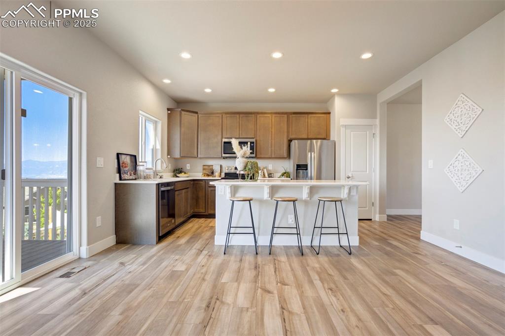 5633 Makalu Drive Colorado Springs, CO 80924 - Photo 11 of 48 a kitchen with a table chairs a refrigerator cabinets and a window