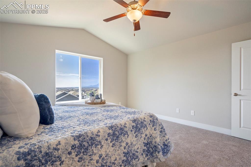 5633 Makalu Drive Colorado Springs, CO 80924 - Photo 25 of 48 a bedroom with a bed and a chandelier