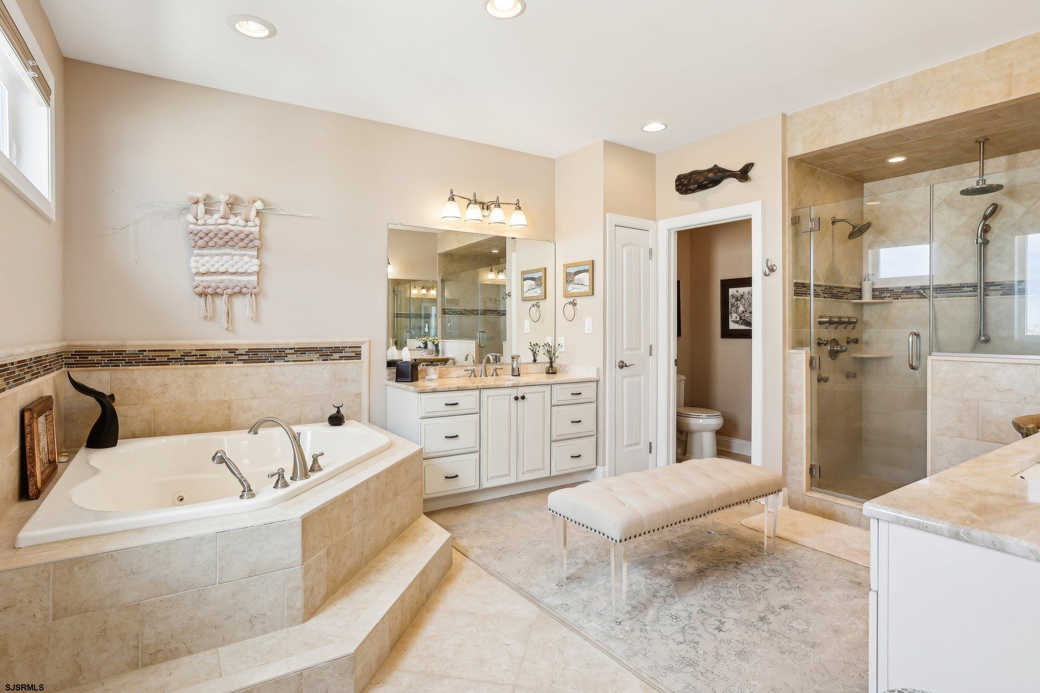 10 Golf Course Drive Brigantine, NJ 08203 - Photo 32 of 56 a bathroom with a tub a sink and a large mirror
