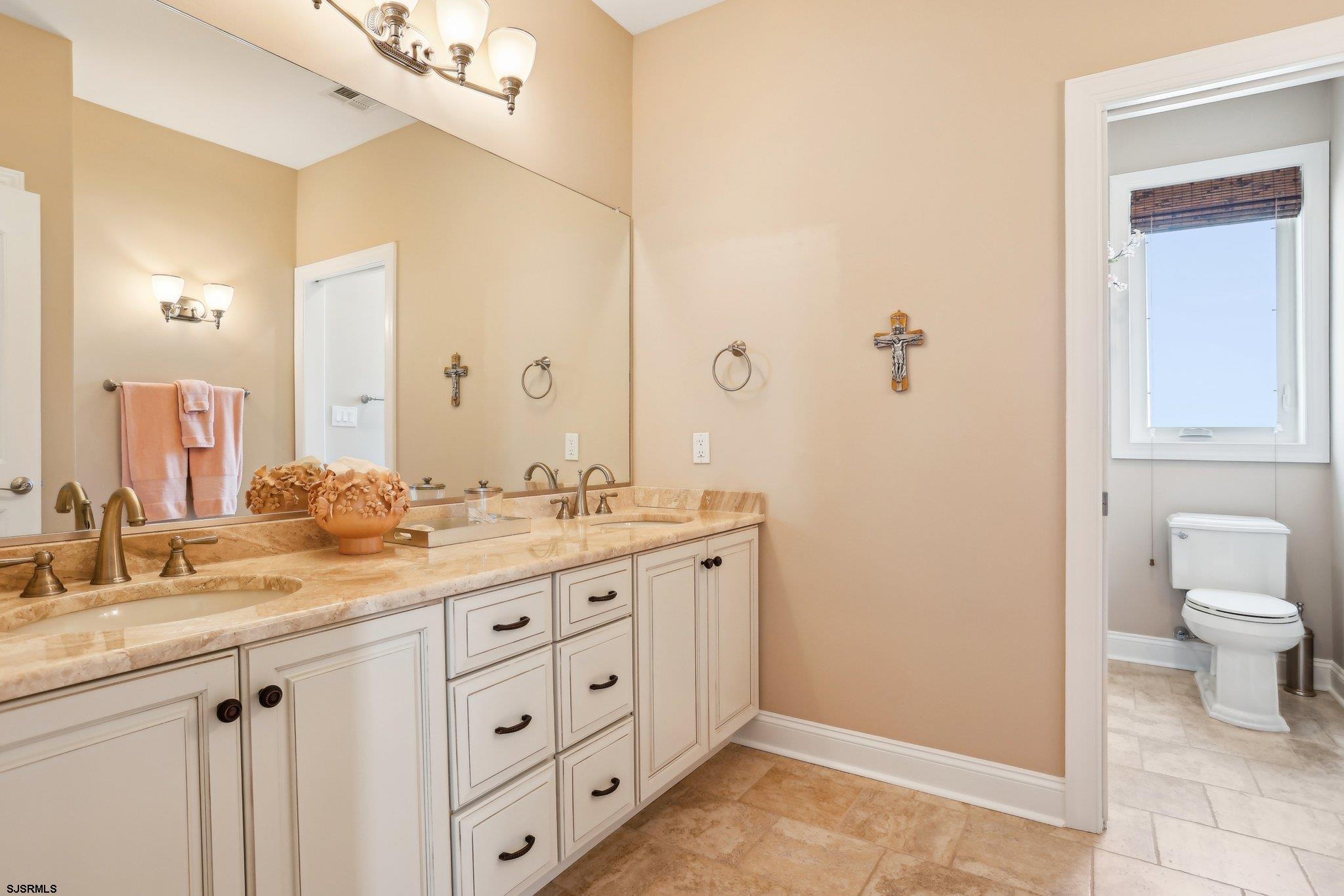 10 Golf Course Drive Brigantine, NJ 08203 - Photo 36 of 56 a bathroom with a granite countertop sink a toilet and a mirror