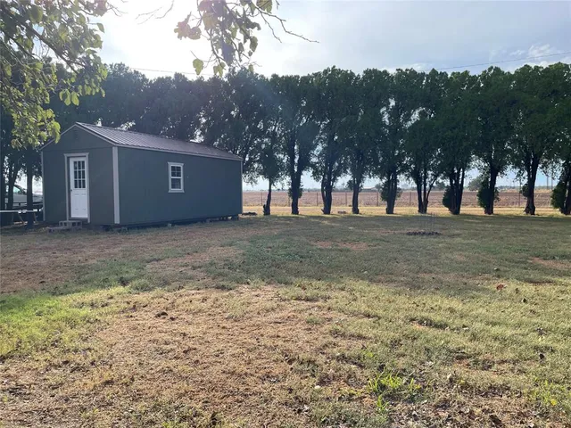 a view of a yard with a house in the background