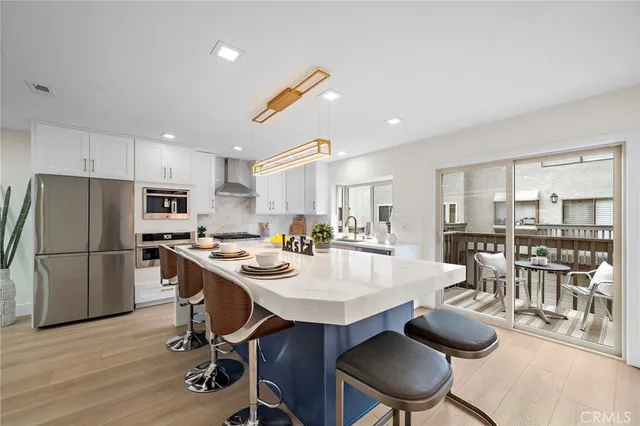 a kitchen with a dining table chairs and refrigerator