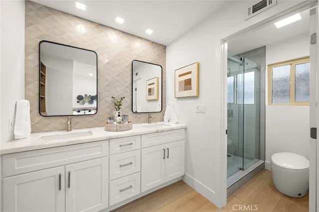 a bathroom with a double vanity sink mirror and toilet
