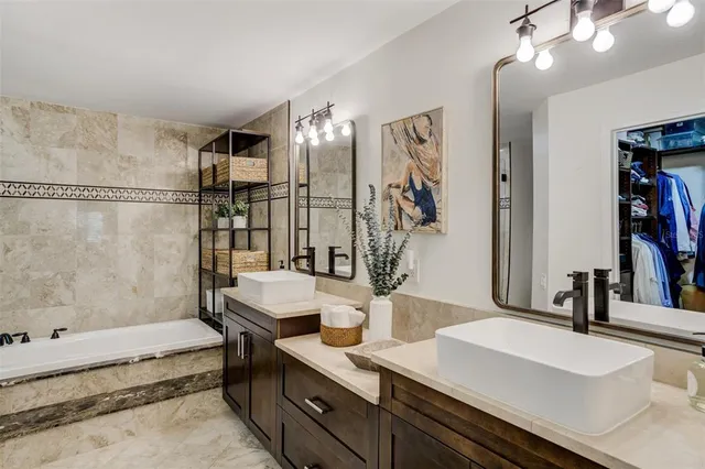 a en suite bathroom with a granite countertop sink and a mirror