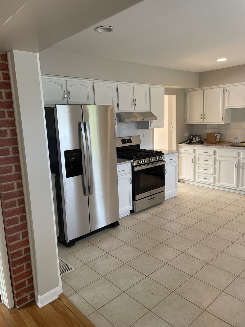 1087 Leahy Circle Des Plaines, IL 60016 - Photo 3 of 9 a kitchen with stainless steel appliances a refrigerator a stove a sink and white cabinets