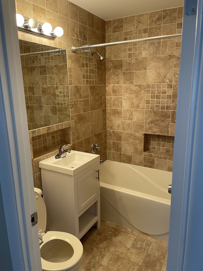1087 Leahy Circle Des Plaines, IL 60016 - Photo 5 of 9 a bathroom with a sink and bathtub with shower