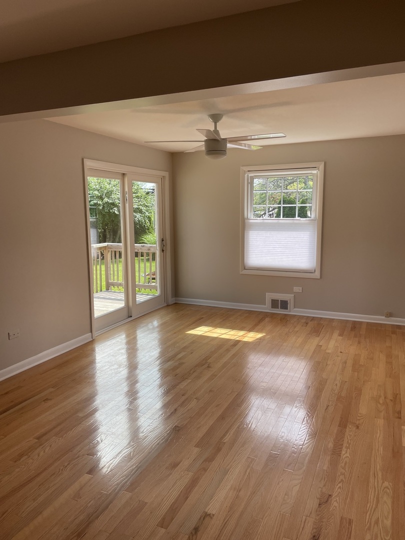 1087 Leahy Circle Des Plaines, IL 60016 - Photo 7 of 9 an empty room with wooden floor and windows