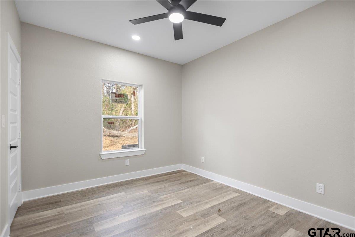 663 Caroline Bend Bullard, TX 75757 - Photo 27 of 36 an empty room with wooden floor chandelier fan and windows