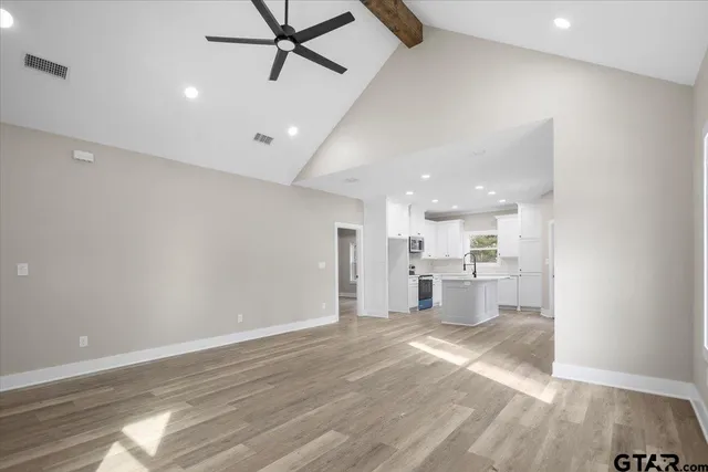 a view of a kitchen with a sink and dishwasher a refrigerator with wooden floor