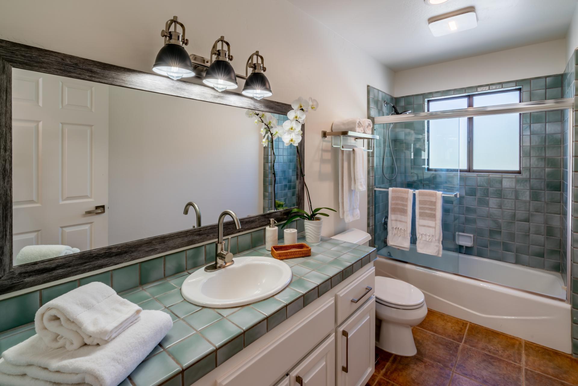 1910 Barker Pass Road Santa Barbara, CA 93108 - Photo 21 of 41 a bathroom with a granite countertop sink a toilet a mirror and shower
