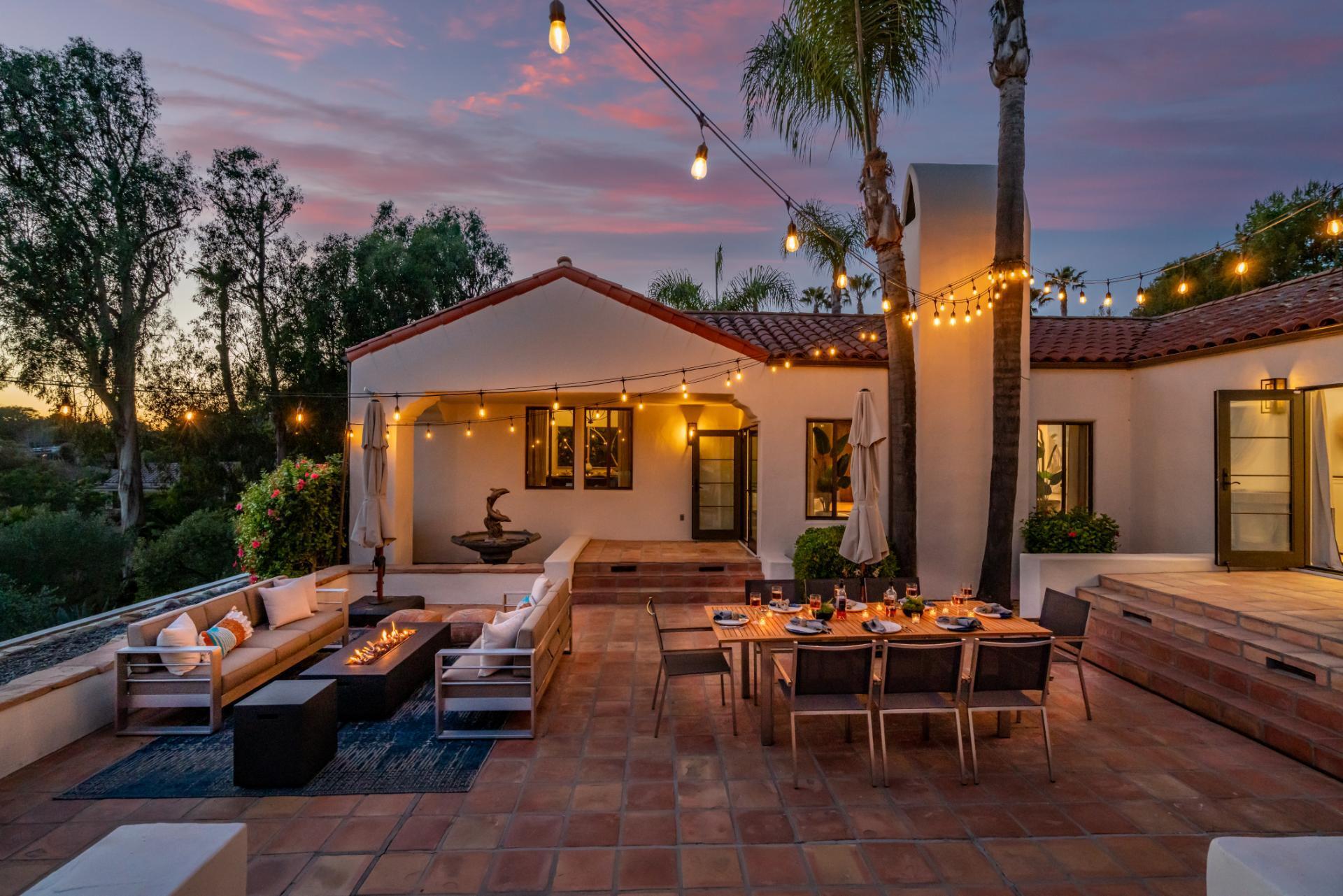 1910 Barker Pass Road Santa Barbara, CA 93108 - Photo 38 of 41 a view of a patio with couches table and chairs under an umbrella with palm trees