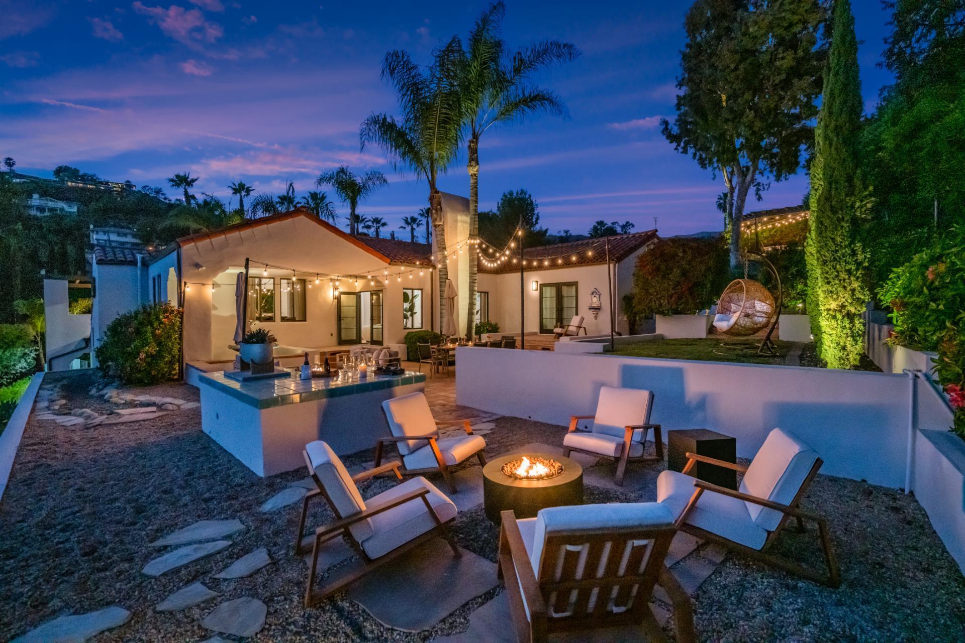 1910 Barker Pass Road Santa Barbara, CA 93108 - Photo 41 of 41 a view of a patio with couches table and chairs under an umbrella with a fire pit