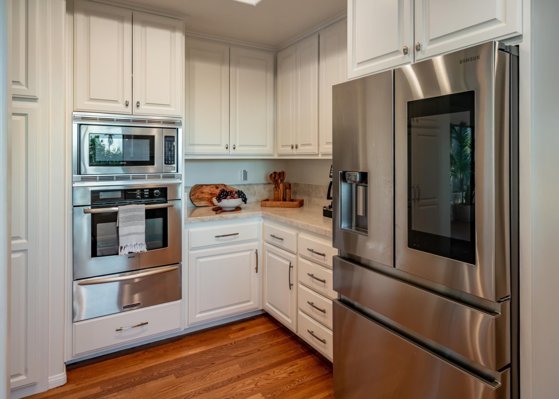 1910 Barker Pass Road Santa Barbara, CA 93108 - Photo 5 of 41 a kitchen with stainless steel appliances white cabinets and wooden floors