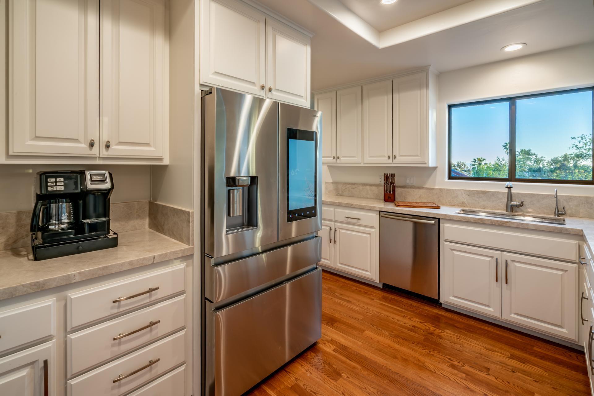 1910 Barker Pass Road Santa Barbara, CA 93108 - Photo 6 of 41 a kitchen with white cabinets and stainless steel appliances