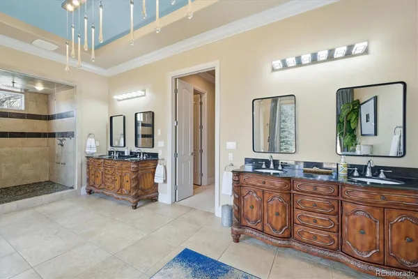 a spacious bathroom with double vanity sinks a mirror a lamp and a glass door