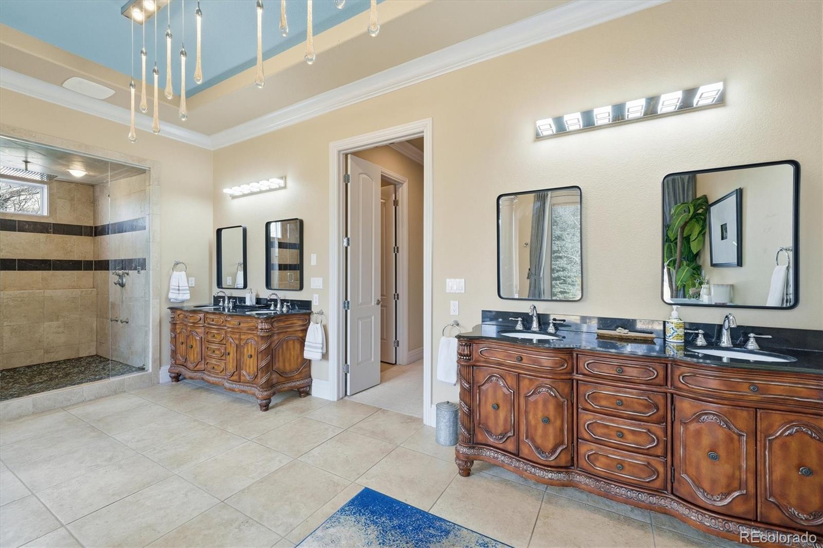 1975 South Lake Road Lakewood, CO 80227 - Photo 15 of 49 a spacious bathroom with double vanity sinks a mirror a lamp and a glass door