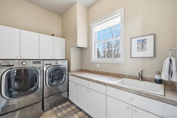 a utility room with sink dryer and washer