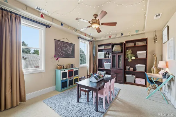 a living room with furniture a ceiling fan and a window