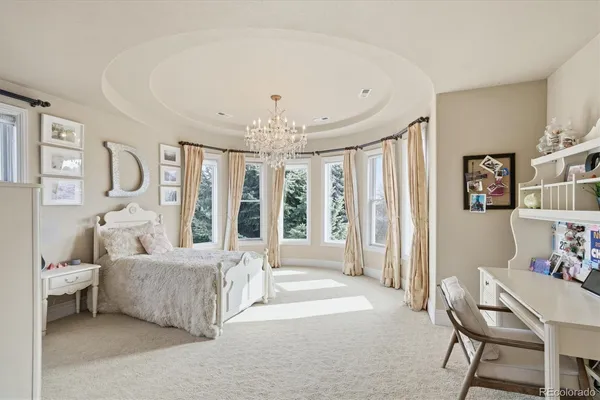 a spacious bedroom with a bed and a chandelier