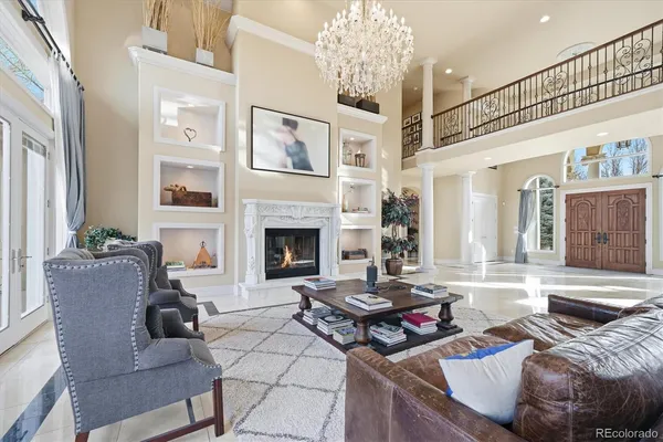 a living room with furniture a chandelier and a fireplace