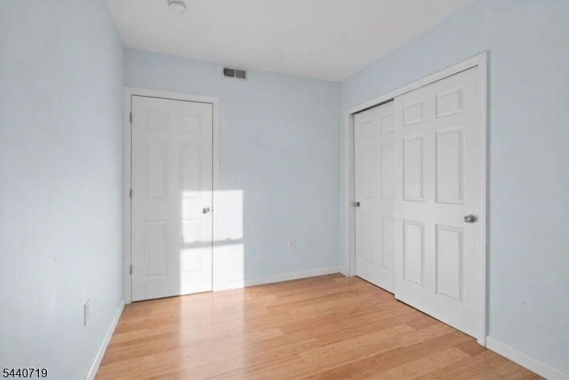 136 Smith Street Elizabeth, NJ 07201 - Photo 26 of 38 a view of empty room with wooden floor and cabinet