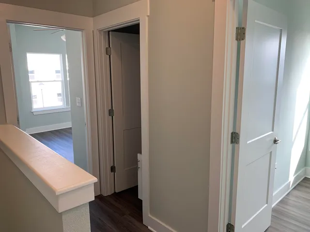 a view of a hallway with entryway and wooden floor