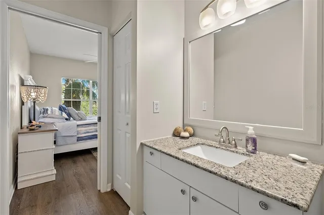 a en suite bathroom with a granite countertop sink and a mirror