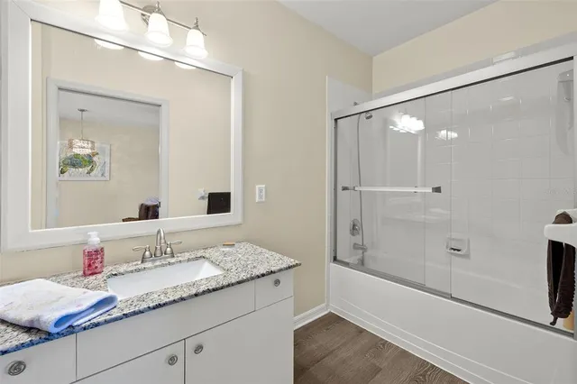 a bathroom with a granite countertop sink mirror and a shower