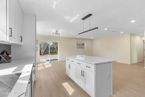 a kitchen with a stove a refrigerator and wooden floor