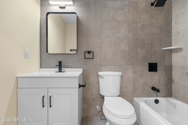 a bathroom with a toilet sink vanity and mirror