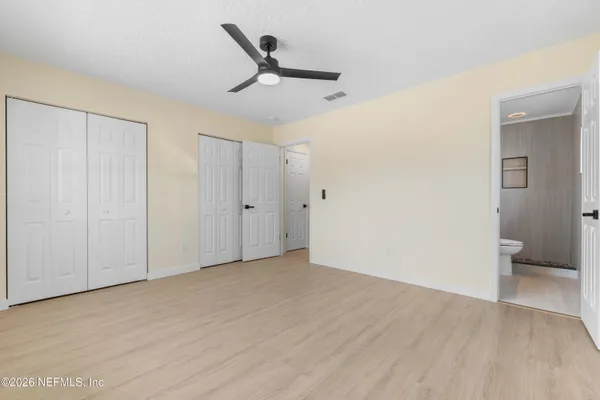 a view of a livingroom with wooden floor and a ceiling fan