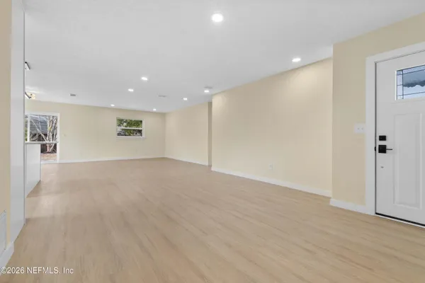 a view of empty room with wooden floor
