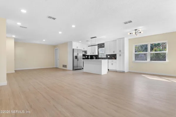 a view of a kitchen with a sink refrigerator and wooden floor