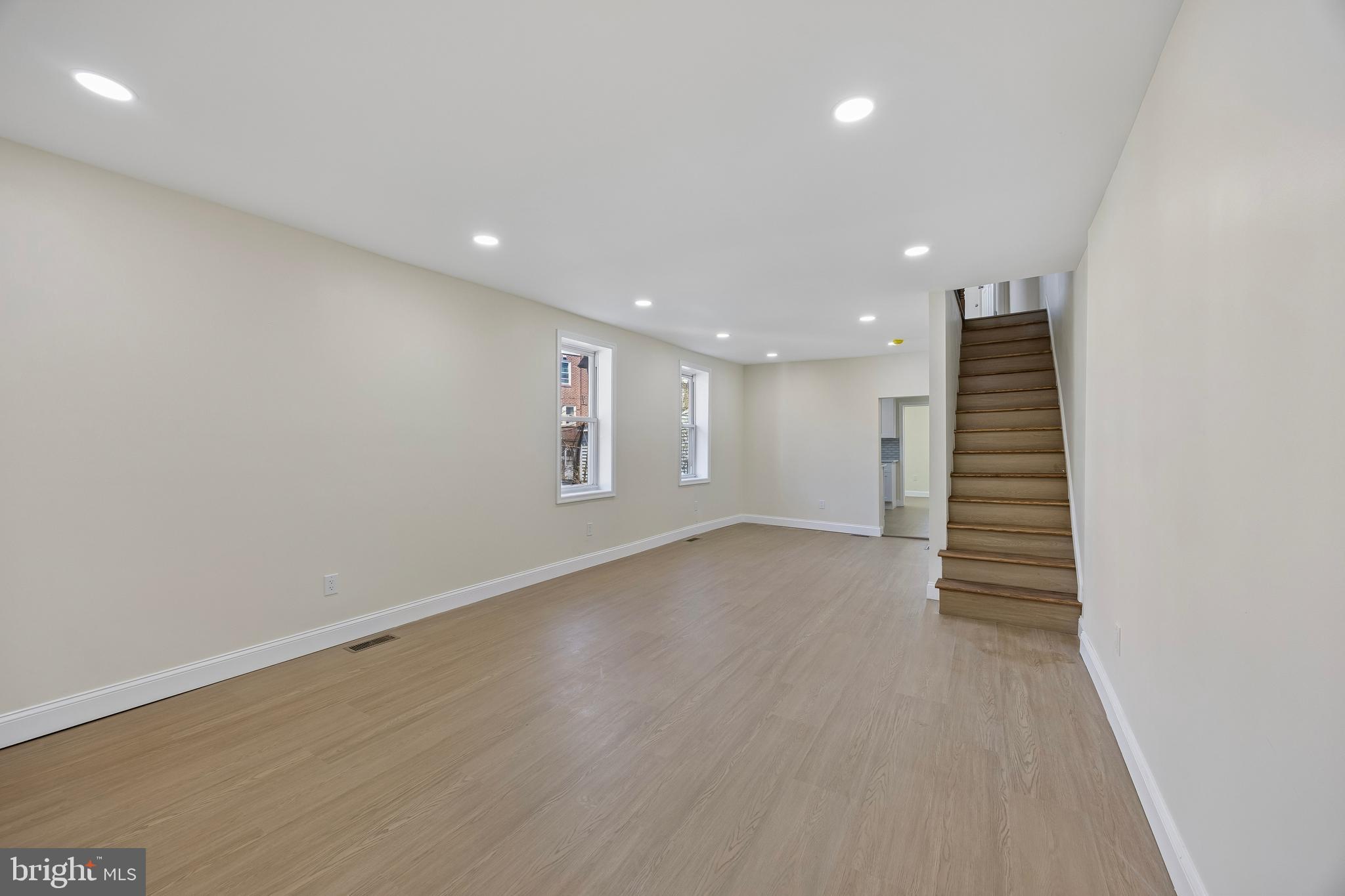 1051 Springfield Road Darby, PA 19023 - Photo 3 of 24 an empty room with wooden floor and white stairs
