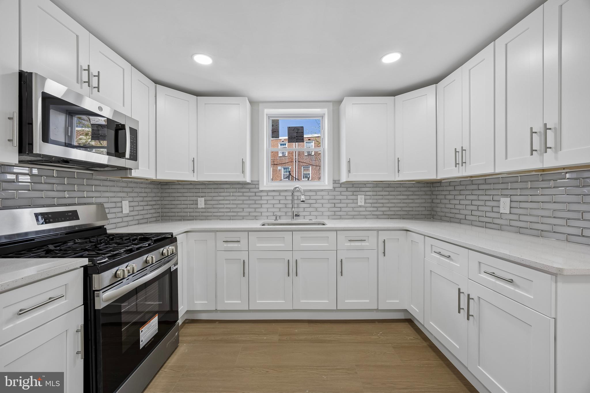 1051 Springfield Road Darby, PA 19023 - Photo 7 of 24 a kitchen with granite countertop white cabinets stainless steel appliances and sink