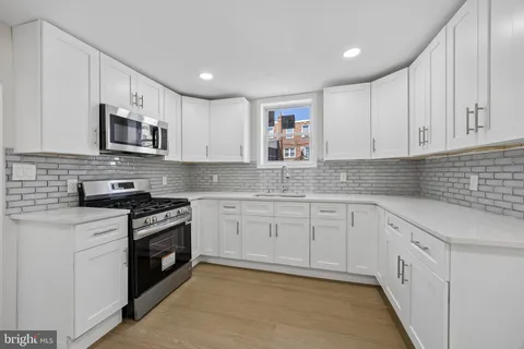 a kitchen with stainless steel appliances granite countertop a stove sink and cabinets