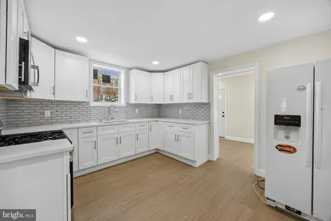 a kitchen with granite countertop white cabinets and white appliances