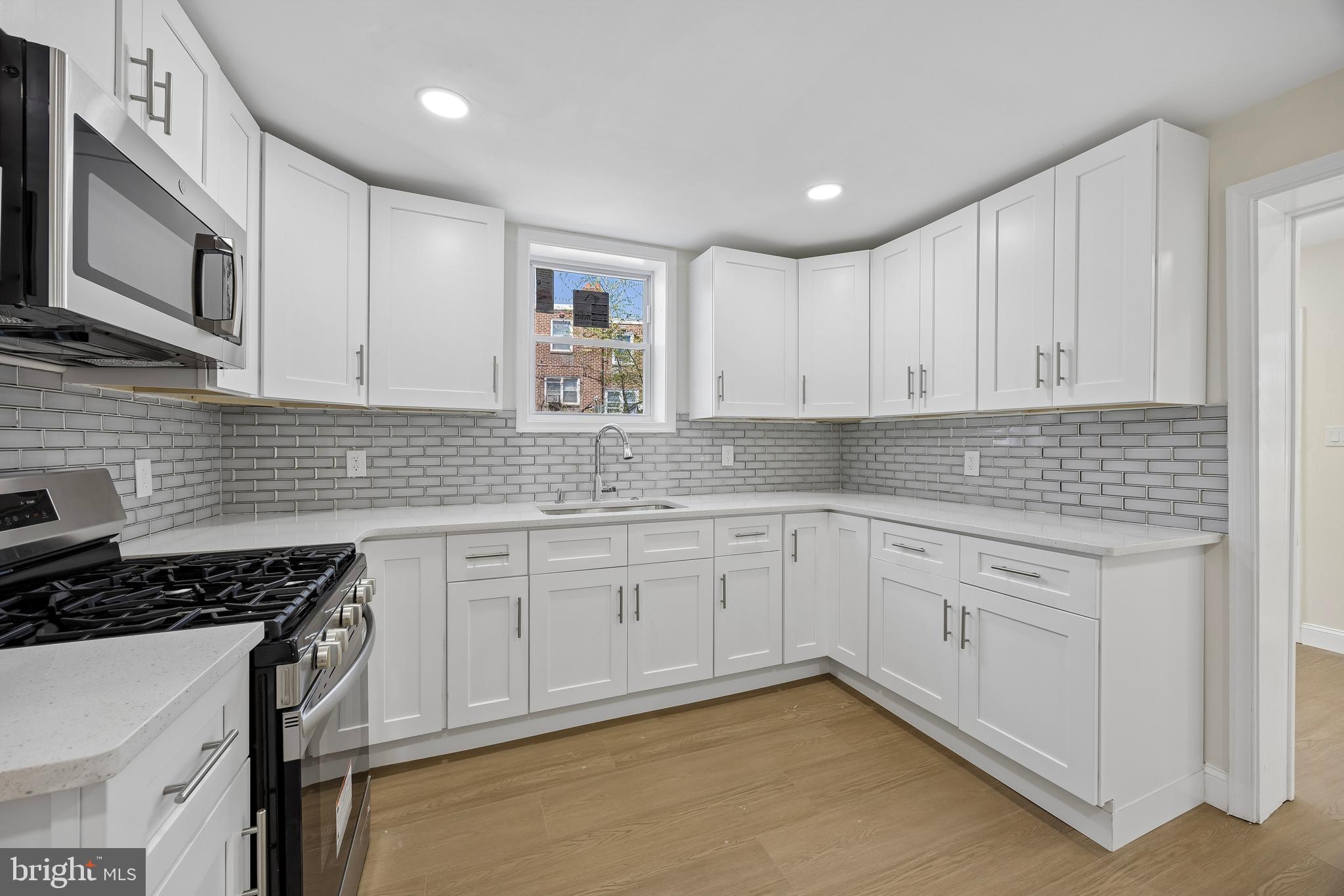 1051 Springfield Road Darby, PA 19023 - Photo 10 of 24 a kitchen with granite countertop white cabinets stainless steel appliances and a sink