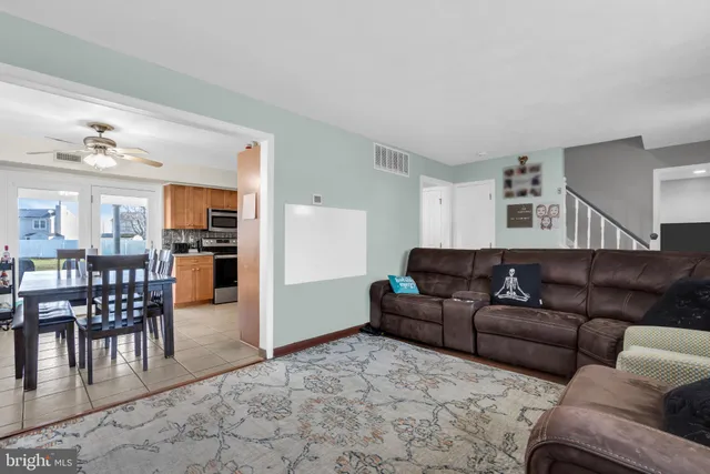 a living room with furniture and a dining table with kitchen view