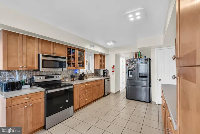 a kitchen with stainless steel appliances granite countertop a refrigerator and a stove top oven