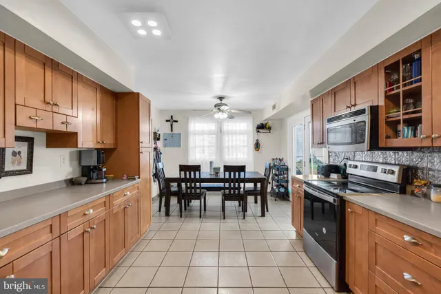 a kitchen with stainless steel appliances granite countertop a stove a sink a dining table and chairs