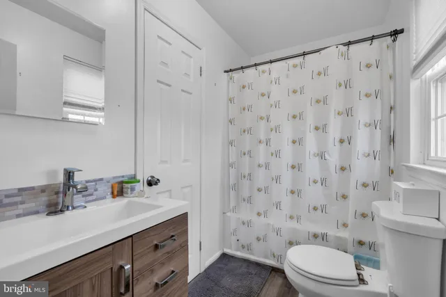 a bathroom with a sink a toilet and shower curtain