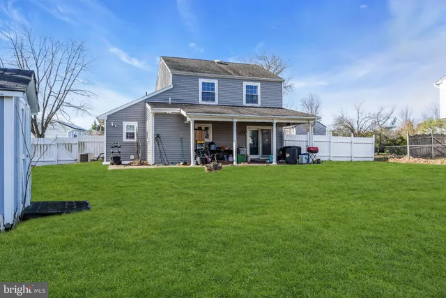 a view of a house with a big yard and large trees