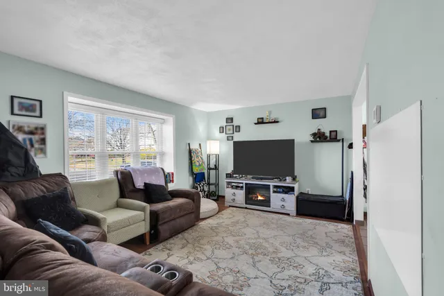 a living room with furniture a window and a flat screen tv