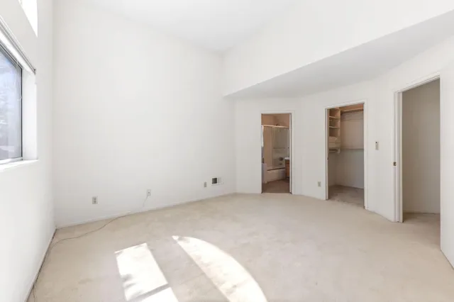 a view of an empty room with closet and entryway