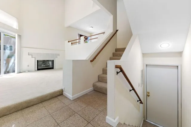 a living room with a fireplace and a ceiling fan