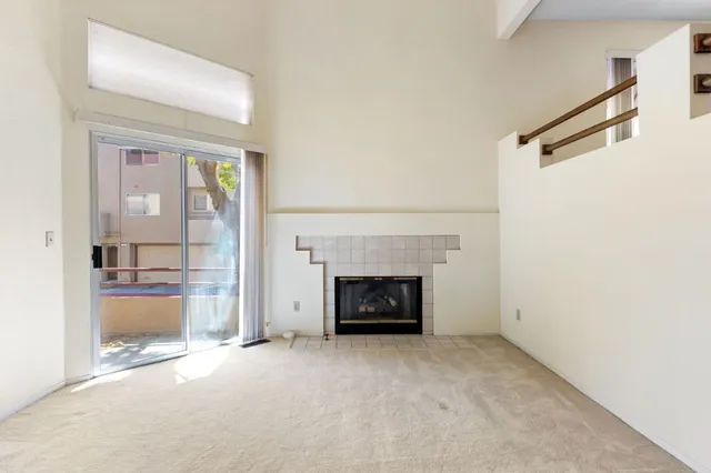 a view of empty room with a fireplace and window