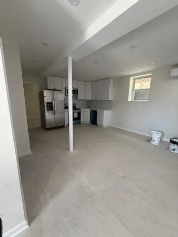 a view of a kitchen with furniture and a refrigerator