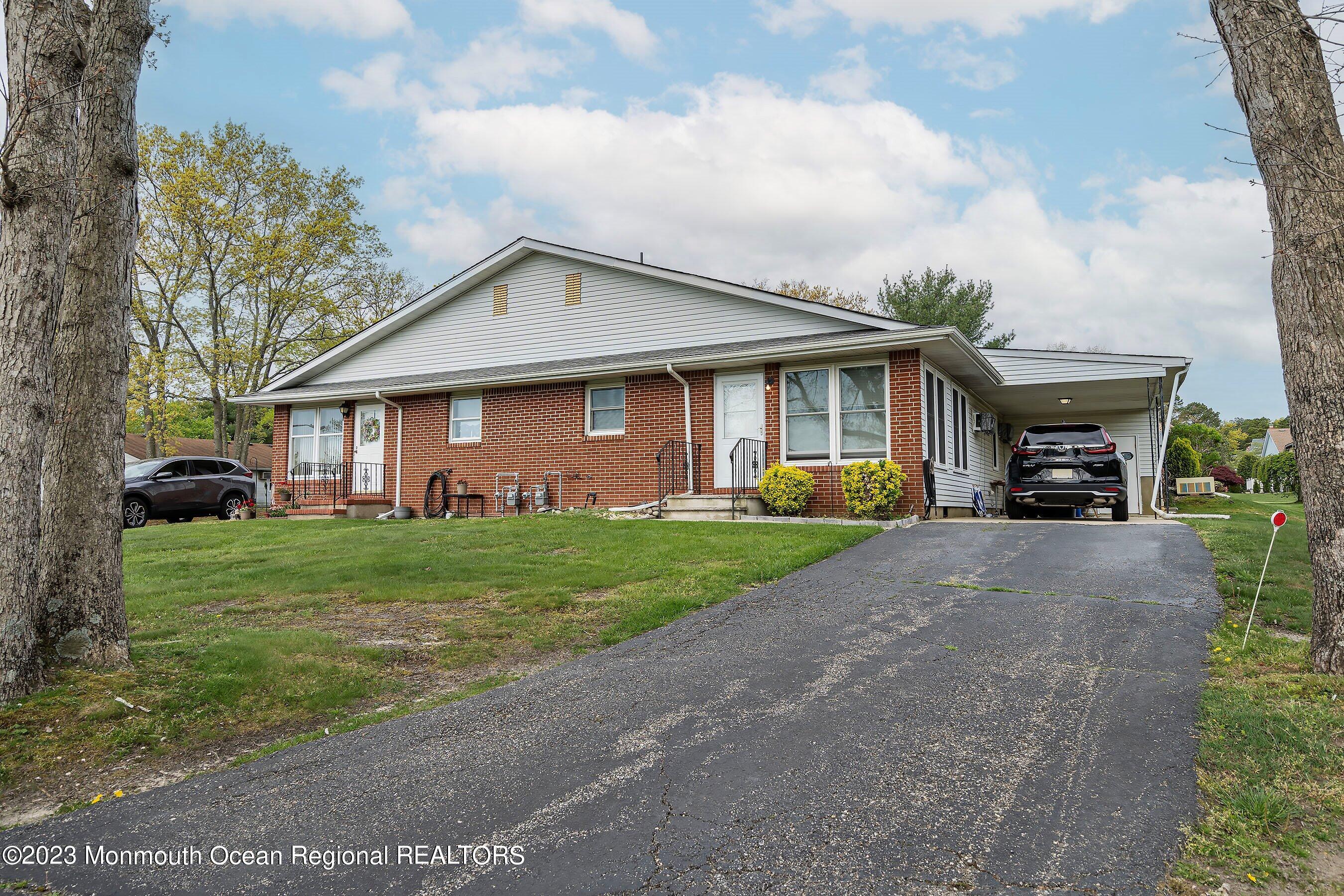 16 B Magnolia Road, Unit 1A Manahawkin, NJ 08050 - Photo 3 of 21 a front view of a house with a garden and pathway